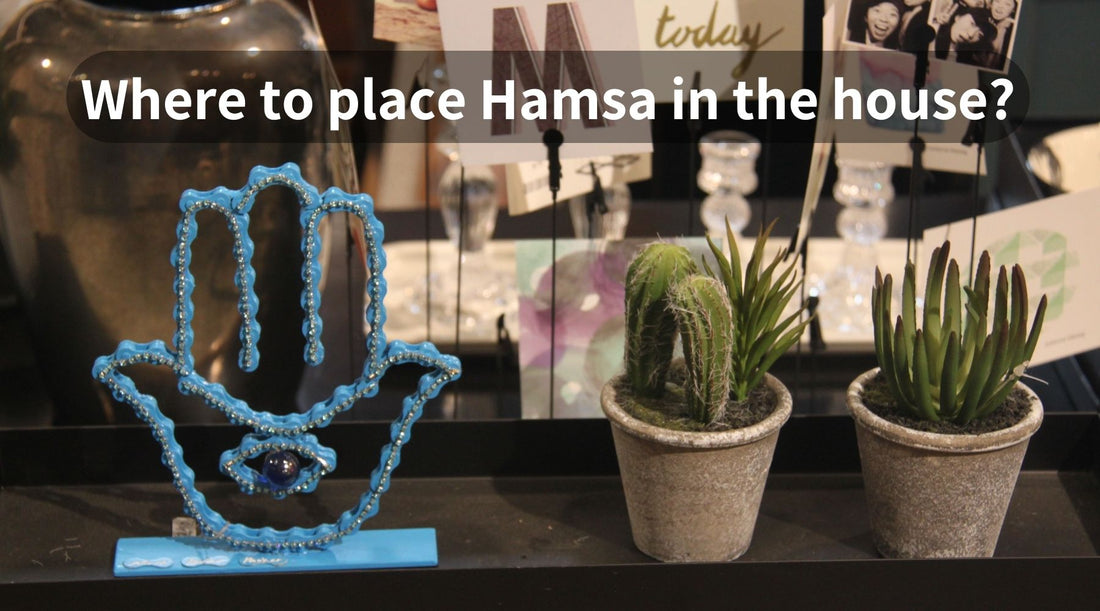 Hamsa statue next to 2 small succulent